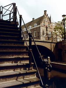 64861 Gezicht op een gedeelte van de Nieuwegracht te Utrecht, met een werftrap en in het midden de Paulusbrug; op de ...